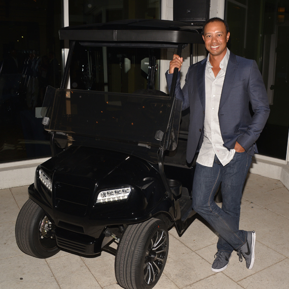 Tiger Woods poses with live auction item, Lacern Golf Cart